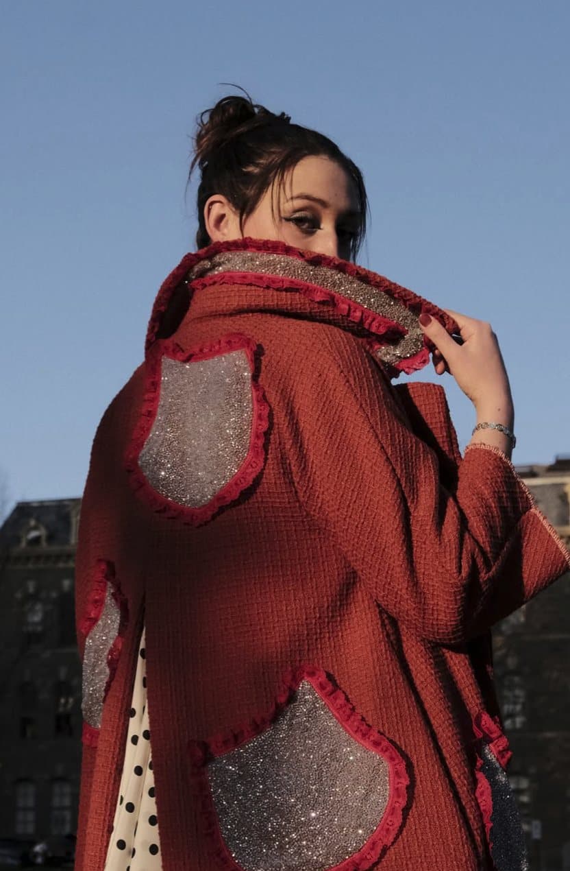 Back view of the red coat with ruffle-trimmed sparkly patches, Remy looking over her shoulder